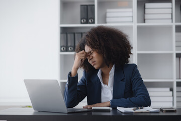 African American businesswoman are stressed and tired from work sitting at desk in the office, feeling sick at work, stress from work.	