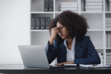 African American businesswoman are stressed and tired from work sitting at desk in the office,...