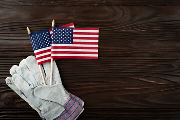 Labor day background of protective gloves and us flag on wooden planks
