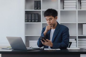 Asian businessman working online with laptop at desk in office, businessman online training concept. 