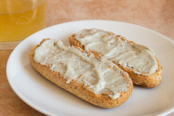 Close-up of Cabrales cream on toasted wholemeal bread with a shot of cider in the background. Traditional Spanish recipes and blue cheese.