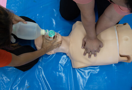 First aid CPR chest pumping. Instructor showing resuscitation technique with holding oxygen mask. Basic life support training.