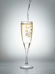 Champagne pouring into a glass on a gray background