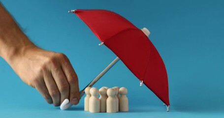 Insurance agent is holding umbrella and figurine people. Protection safety insurance