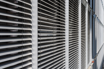 closed automated external Venetian blinds protecting an office building from sunlight and heat. 
