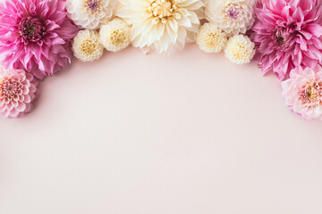 Border of beautiful autumn dahlia flowers on pastel background top view.