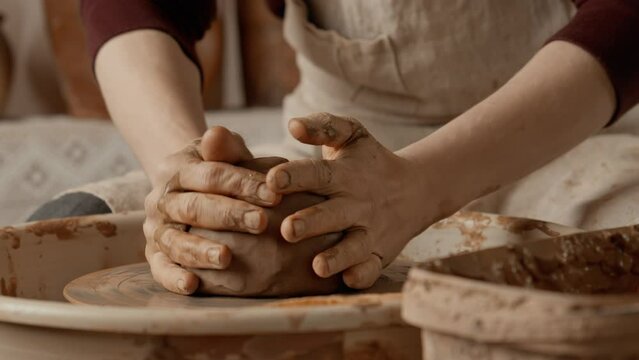 Potter preparing clay for work in pottery workshop. Working process in ceramic workshop. Hands of potter with clay. Close-up in 4K, UHD