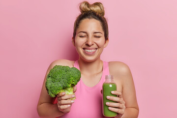 Healthy detox diet for weight loss. Positive European woman with hair gathered in bun keeps eyes...