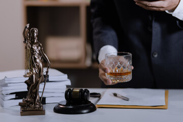 Law holding a glass of whiskey at desk, justice and law, attorney, court judge, concept.