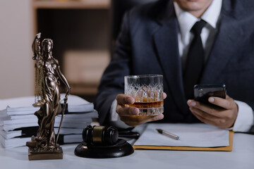 Fototapeta na wymiar Law holding a glass of whiskey at desk, justice and law, attorney, court judge, concept.