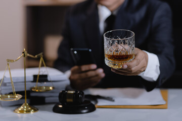 Law holding a glass of whiskey at desk, justice and law, attorney, court judge, concept.