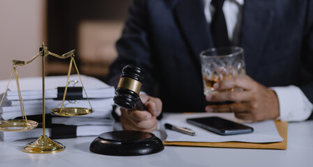 Law holding a glass of whiskey at desk, justice and law, attorney, court judge, concept.
