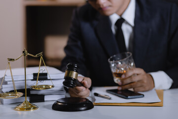Law holding a glass of whiskey at desk, justice and law, attorney, court judge, concept.