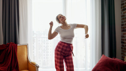 Portrait of happy smiling woman dancing at home in morning. People relaxing at home, having fun, positive emotions and fun.
