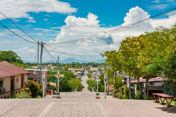 Obraz premium Streets of Nagarote with a view of the momotombo volcano on a suny day. View of the streets of Nagarote with a view of the Momotombo volcano, Nicaragua