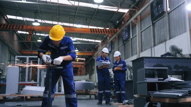 Worker man using grinding machine and cutting steel have spark from the grinding wheel at production factory industrial.Expert Man working hard in steel manufacturing plant.Factory  industry concept