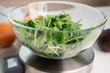salad in a bowl on an electronic kitchen scales, weigh food, cooking a recipe