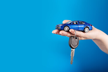 Buying a car, Motor vehicle rent, Lease or purchase, car and car keys in hand on a blue background,...