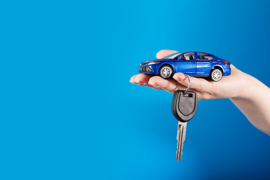 Buying a car, Motor vehicle rent, Lease or purchase, car and car keys in hand on a blue background, copy space