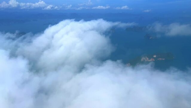 Flying over Phangna heading to phuket island airport with James Bond Islands below and clouds passing by fast phuket Thailand 