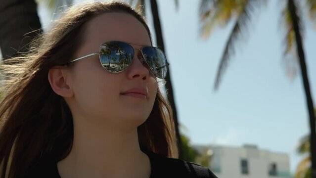 Young pretty woman enjoys the sun of Miami Beach - extreme slow-motion video