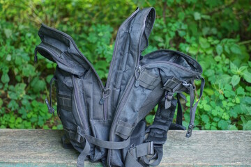 one large open black army backpack stands on a gray table in the street against the backdrop of...