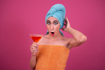 Party and delicious cocktails. Funny drag queen posing in the studio on a pink background.