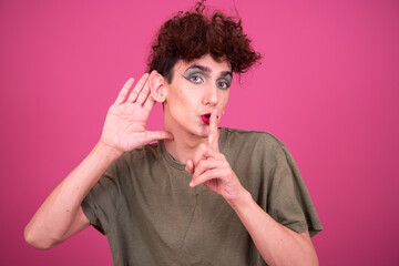 Make up. Funny drag queen posing in the studio on a pink background.