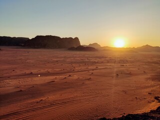 Couchée du Soleil sur une dune rocheuse du désert de Wadi Rum, en Jordanie, plaine sableuse,...