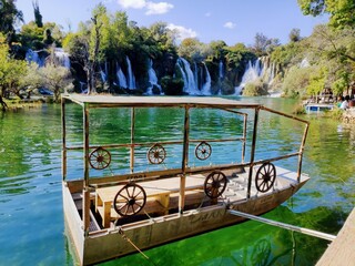 Petit bateau en bois traditionnel et croate, circulant sur un magnifique lac vert et bleu, avec de...