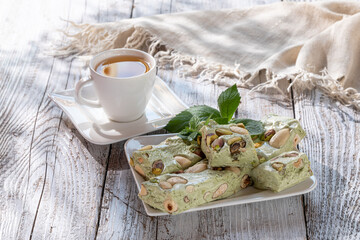 nougat with nuts on a white dish on a wooden table in the sun