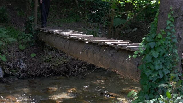 A wooden bridge on a forest river, footbridge - (4K)