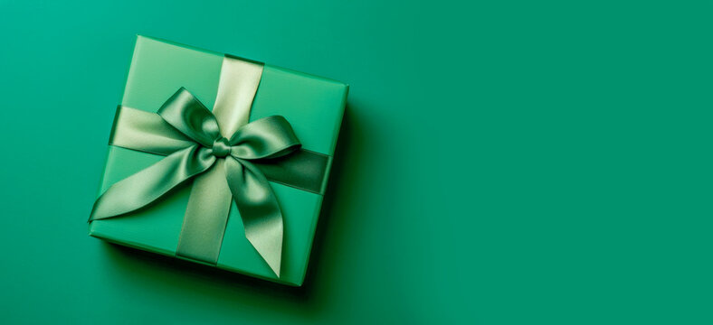 Banner with green gift box with ribbon and bow for man and boy isolated on green background.Holiday gift with Birthday or Christmas present,flat lay,top view,father's day copy space.Generated by AI