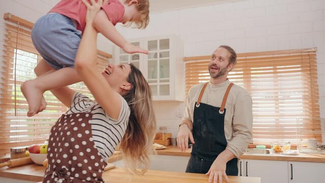 Happy family caucasian parents with children play and tease together during preparation dinner in kitchen at home. Father mother and children spending time together. Family relationship concept