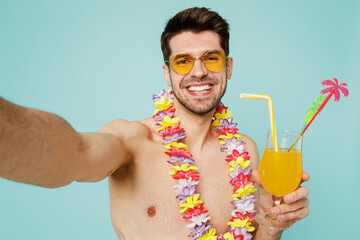 Young man wears green shorts swimsuit glasses hawaiian lei relax near hotel pool drink exotic...