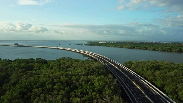 Aerial view to Bali Mandara toll Road. View from the mangroves. A beautiful road across the ocean on which cars and mopeds drive.