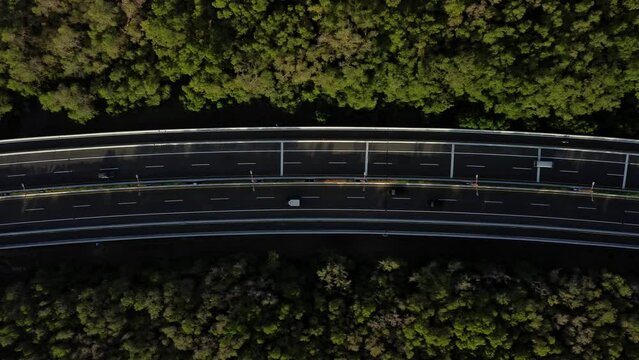 Top view to Bali Mandara Toll. Cars move along the road through the mangroves.