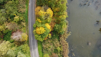 Zdjęcie parku z drona na którym widać drzewa, jezioro i drogę / Park photo from the drone with...