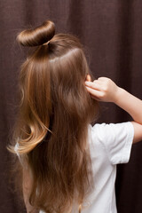 Rearview of little girl's head showing hair tied in bun.