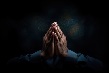 Close up of man praying with hands clasped together against dark background - obrazy, fototapety, plakaty