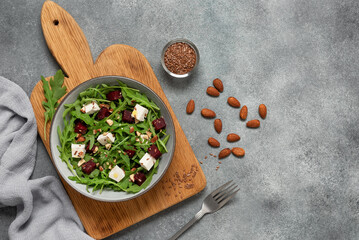 Salad with beets, arugula and cheese background. Diet healthy salad. Gray concrete background. View from above.