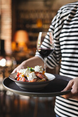 Delicious salad with tomatoes, feta cheese, croutons on a dark background. Food photography.