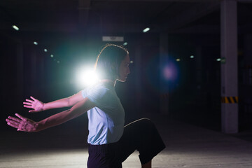 Fototapeta na wymiar Young woman dancer enjoying dancing at night in the street