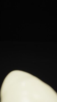 Squeezing toothpaste on a toothbrush. Dolly slider extreme close-up. Laowa Probe Vertical video.