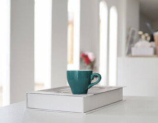 Cup of coffee on notebook. Glasses. At coffee shop. Blurred background.