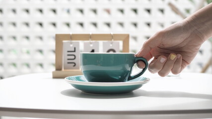 hand holding a cup of coffee in the morning