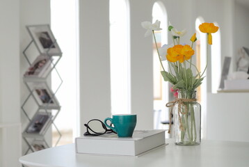 Cup of coffee on notebook. Glasses. At coffee shop. Blurred background.