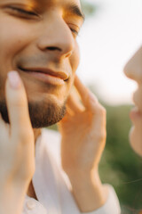 Close up of a beautiful young happy couple in love embracing while spending time in the park. The concept of a happy relationship in marriage. No focus blurred and noise effect