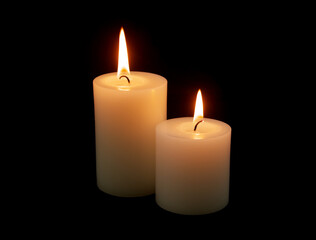 Fototapeta na wymiar Two white candles burning on black background.