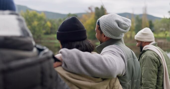 Back, walking and a couple of friends on a fishing trip by a lake in nature together while on holiday or vacation. Travel, adventure and a group of young men and women in the wilderness to explore